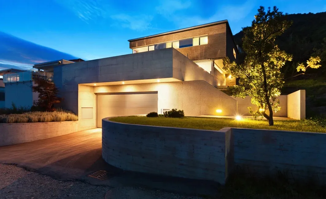 Outdoor lighting across a home and garden at dusk