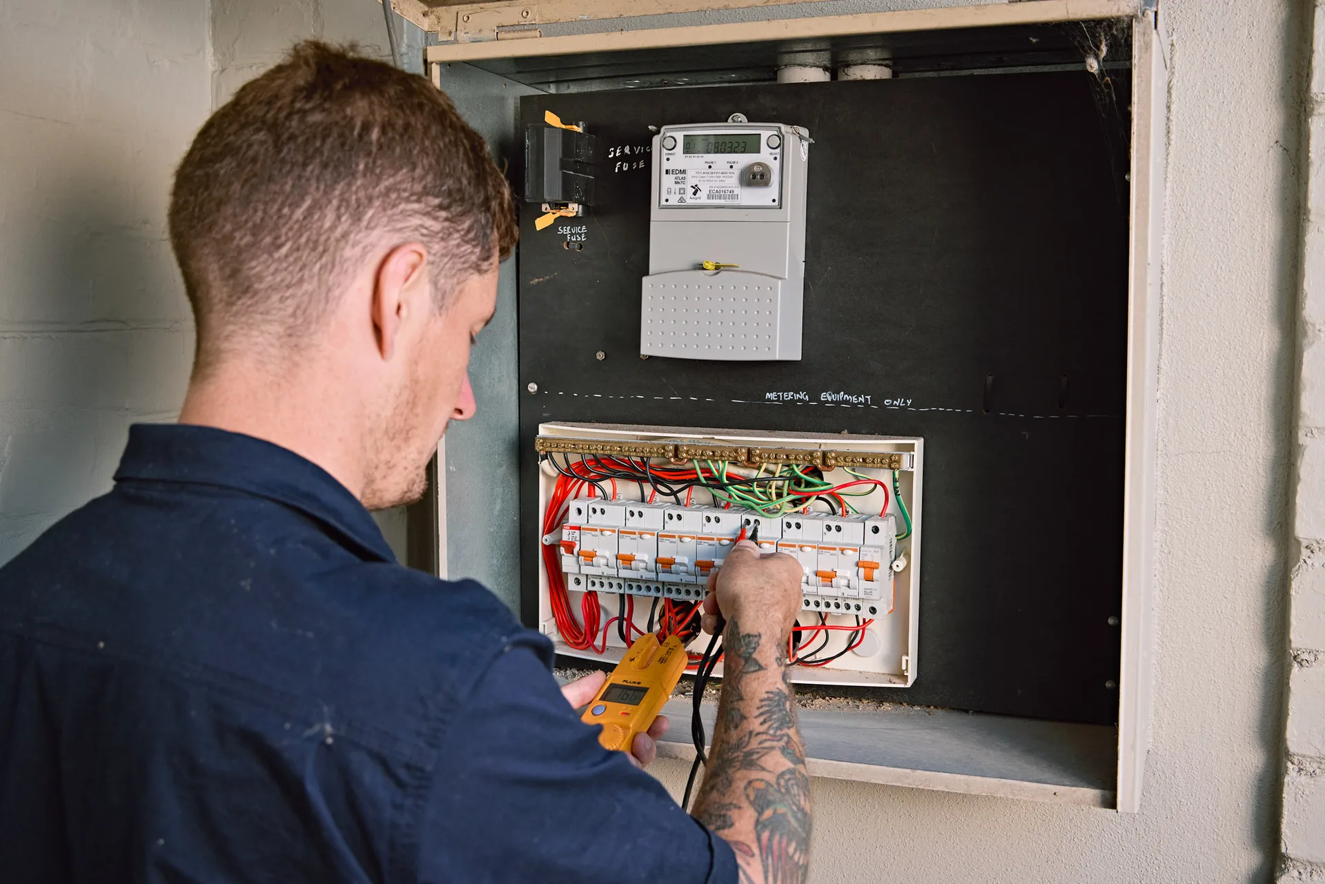 Electrician walking a customer through their switchboard